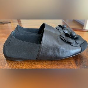Chanel black leather and grosgrain flats with iconic leather camellia on top.